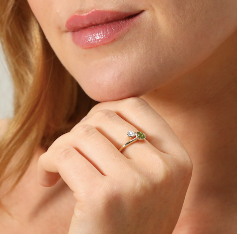 Contemporary peridot and diamond cross over ring