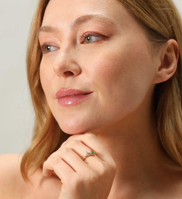 Contemporary peridot and diamond cross over ring