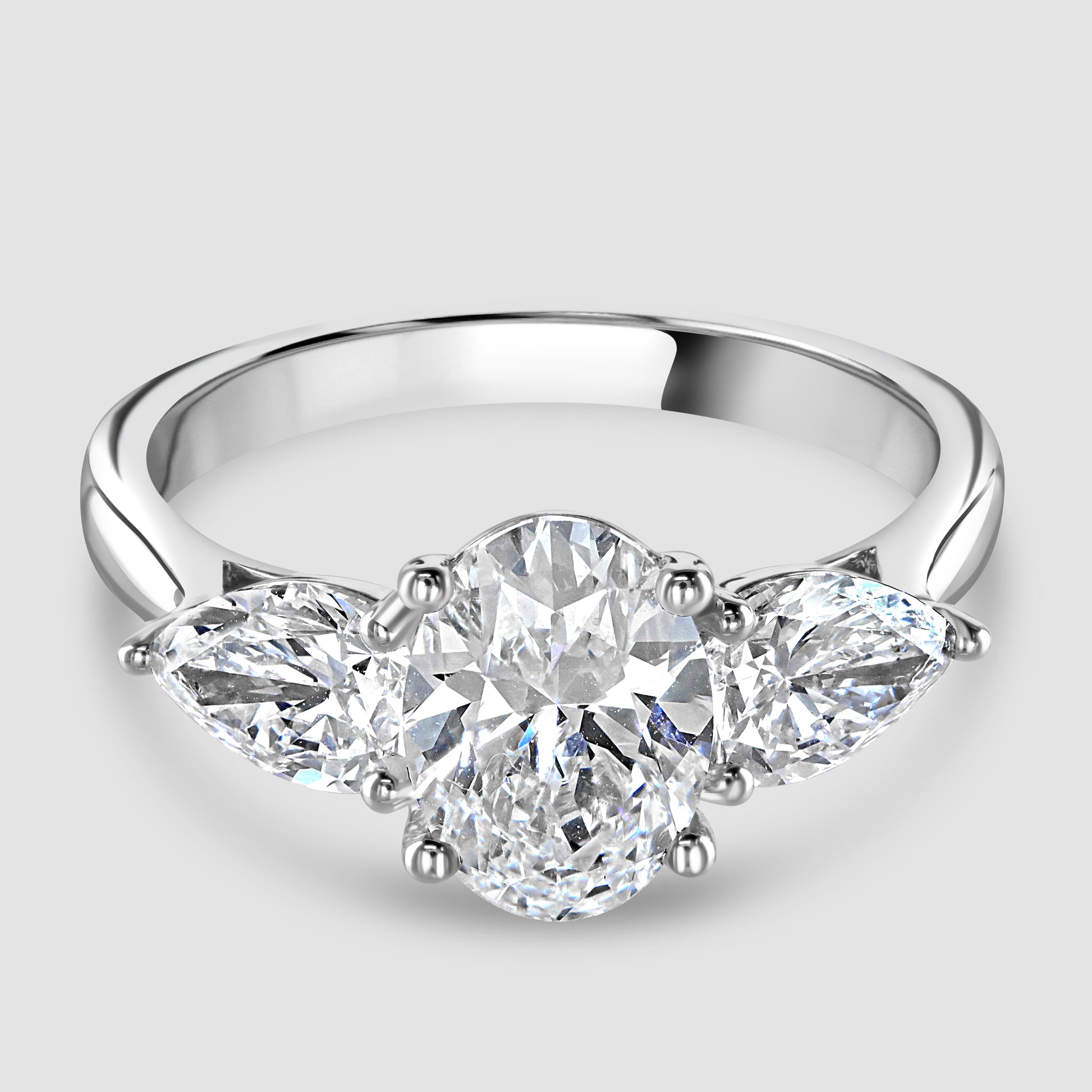 Laboratory diamond three stone oval and pear shape ring 