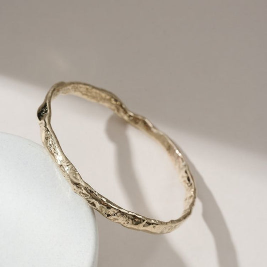 A Luna Textured Gold Bangle from Lulu and Boo Jewellery.
